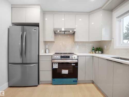 Kitchen featuring stainless steel appliances, tasteful backsplash, modern cabinets, and light wood-style flooring - 9409 173 Street, Edmonton, AB - Indoor Photo Showing Kitchen With Upgraded Kitchen