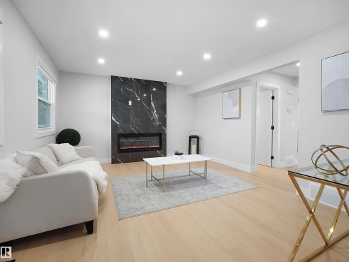 Living room with a premium fireplace, light wood-style floors, and recessed lighting - 9409 173 Street, Edmonton, AB - Indoor With Fireplace