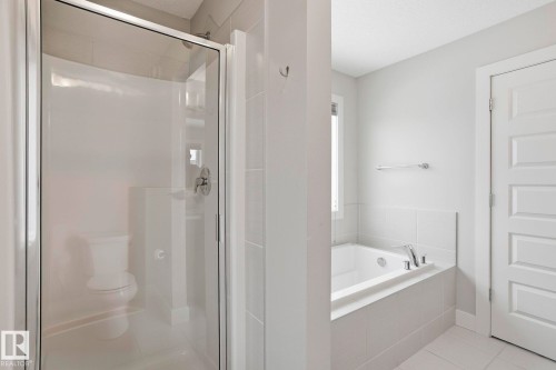 Full bathroom with a shower stall, a bath, and light tile patterned flooring - 1915 77 Street Sw, Edmonton, AB - Indoor Photo Showing Bathroom