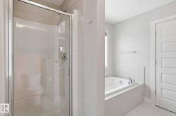 Full bathroom with a shower stall, a bath, and light tile patterned flooring - 