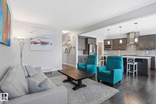 Living area with dark wood-type flooring and baseboards - 1915 77 Street Sw, Edmonton, AB - Indoor