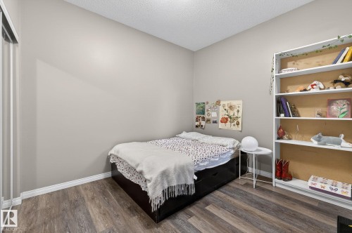 Bedroom featuring dark wood finished floors and a textured ceiling - 103 8108 109 Street, Edmonton, AB - Indoor Photo Showing Bedroom
