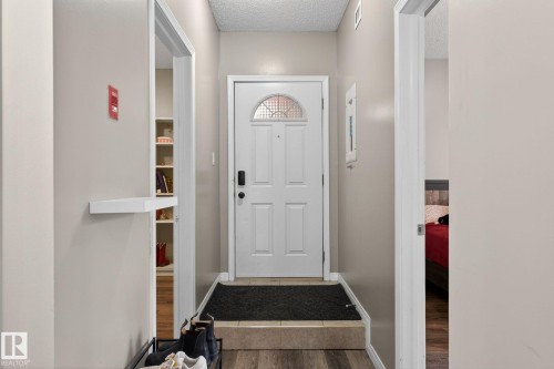 Entryway with wood finished floors and a textured ceiling - 103 8108 109 Street, Edmonton, AB - Indoor Photo Showing Other Room