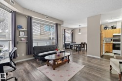 Living area with dark wood finished floors, a textured ceiling, and a desk - 