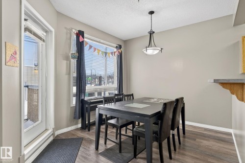 Dining space featuring wood finished floors and a textured ceiling - 103 8108 109 Street, Edmonton, AB - Indoor Photo Showing Dining Room
