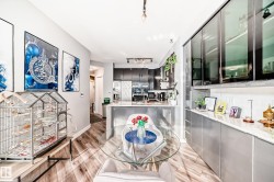 Kitchen featuring a peninsula, stainless steel fridge with ice dispenser, tasteful backsplash, light wood-style flooring, and modern cabinets - 