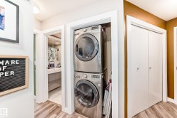 Laundry area featuring stacked washer / drying machine and light wood-type flooring - 