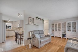 Living room with light wood-style flooring and a textured ceiling - 