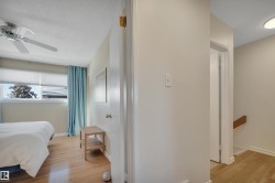 Bedroom featuring a textured ceiling, light wood-style flooring, and ceiling fan - 