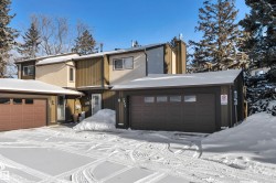 View of front of house featuring a chimney and a garage - 