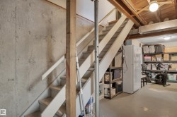 Basement with stairs and freestanding refrigerator - 