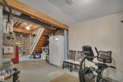 Unfinished below grade area with freestanding refrigerator and heating unit - 