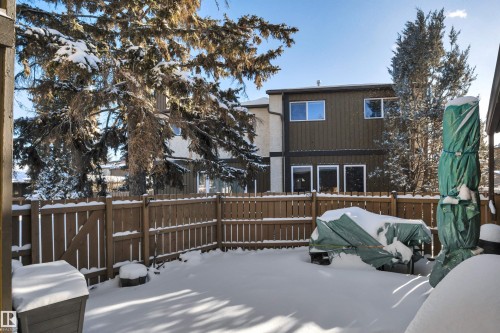 Snow covered property with a fenced backyard and a deck - 7075 32 Avenue, Edmonton, AB - Outdoor