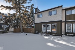 Snow covered rear of property featuring a chimney and board and batten siding - 