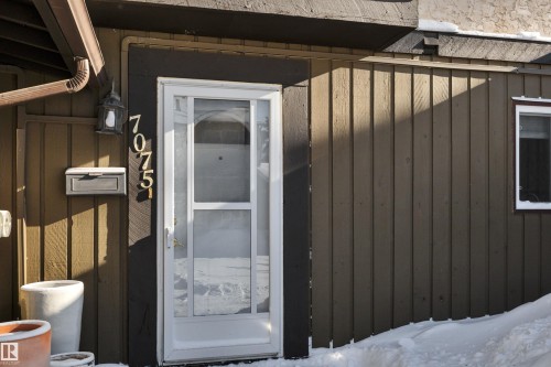 Property entrance with board and batten siding - 7075 32 Avenue, Edmonton, AB - Outdoor With Exterior