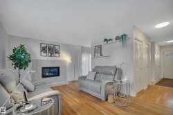 Living area with light wood-type flooring, a premium fireplace, and a textured ceiling - 
