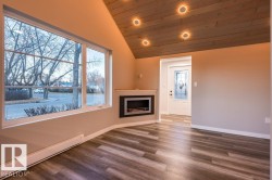 Unfurnished living room with baseboard heating, dark wood-type flooring, a vaulted wooden ceiling, recessed lighting, and a fireplace - 