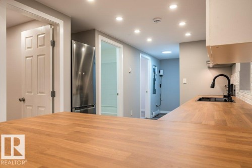 Kitchen featuring butcher block counters, freestanding refrigerator, recessed lighting, and a peninsula - 4713 48 Avenue, Wetaskiwin, AB - Indoor