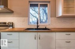 Kitchen featuring white cabinets, stainless steel electric range, and wooden counters - 
