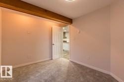 Carpeted spare room with baseboards and beamed ceiling - 
