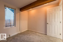 Carpeted empty room featuring a baseboard radiator and beam ceiling - 
