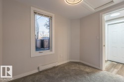 Carpeted spare room featuring baseboard heating and baseboards - 