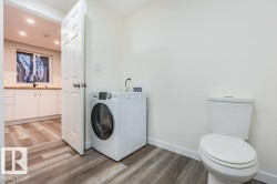 Bathroom with washer / clothes dryer, light wood finished floors, vanity, tasteful backsplash, and recessed lighting - 