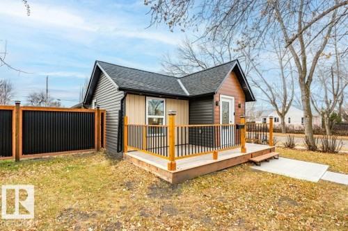 View of side of property featuring a wooden deck and a shingled roof - 4713 48 Avenue, Wetaskiwin, AB - Outdoor With Deck Patio Veranda