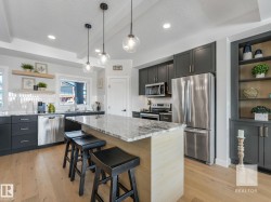Kitchen featuring open shelves, stainless steel appliances, light stone countertops, light wood finished floors, and decorative backsplash - 