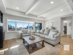 Living room with a textured ceiling, beam ceiling, light wood-style flooring, and recessed lighting - 
