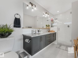 Full bath with double vanity, a stall shower, decorative backsplash, and light tile patterned flooring - 