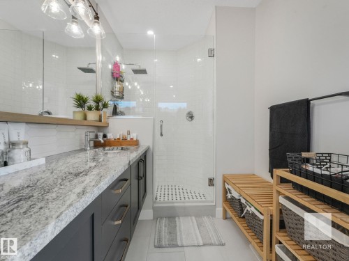 Bathroom with vanity, a shower stall, light tile patterned floors, and tasteful backsplash - 209 55101 Ste. Anne Trail, Rural Lac Ste. Anne County, AB - Indoor Photo Showing Bathroom