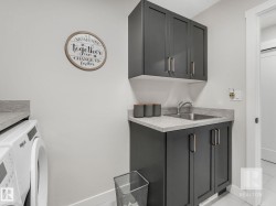 Laundry area with light tile patterned flooring and cabinet space - 