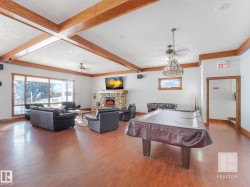 Game room with beam ceiling, a fireplace, ceiling fan, and billiards table - 