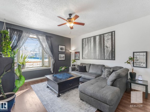 Living area featuring wood finished floors, ceiling fan, and a textured ceiling - 4504 48 Avenue, Onoway, AB - Indoor Photo Showing Living Room