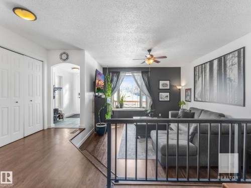 Living room with arched walkways, a textured ceiling, ceiling fan, and wood finished floors - 4504 48 Avenue, Onoway, AB - Indoor Photo Showing Other Room
