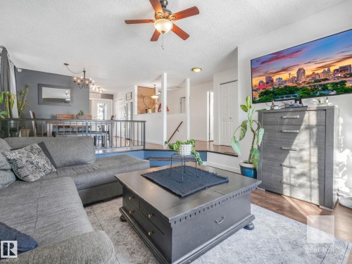 Living room with ceiling fan, wood finished floors, a textured ceiling, and a chandelier - 4504 48 Avenue, Onoway, AB - Indoor Photo Showing Living Room