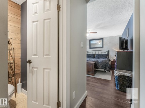 Hall with a textured ceiling and wood finished floors - 4504 48 Avenue, Onoway, AB - Indoor Photo Showing Other Room