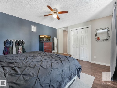 Bedroom with dark wood-style floors, a closet, a ceiling fan, a textured ceiling, and arched walkways - 4504 48 Avenue, Onoway, AB - Indoor Photo Showing Bedroom