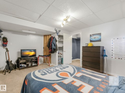 Carpeted bedroom with a drop ceiling and a walk in closet - 4504 48 Avenue, Onoway, AB - Indoor
