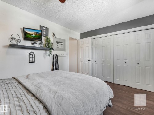Bedroom with dark wood-style flooring, a closet, and a textured ceiling - 4504 48 Avenue, Onoway, AB - Indoor Photo Showing Bedroom