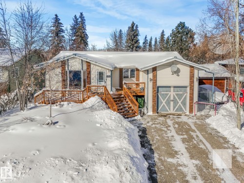 View of front of property featuring brick siding, a wooden deck, driveway, and a garage - 4504 48 Avenue, Onoway, AB - Outdoor