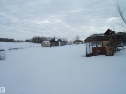 Yard layered in snow with a shed - 