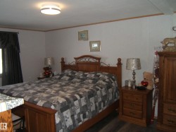 Bedroom featuring ornamental molding and dark wood-style floors - 