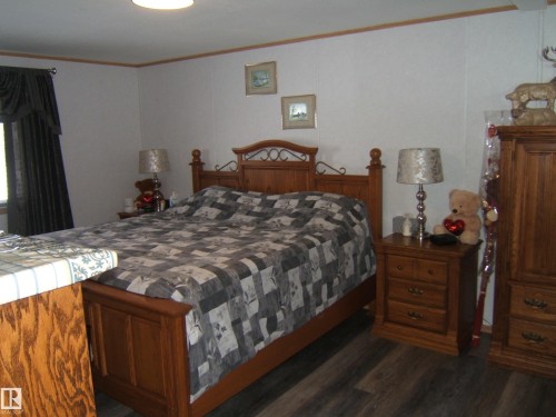 Bedroom with dark wood-style flooring and ornamental molding - 125076 Twp Rd 540, Rural Two Hills County, AB - Indoor Photo Showing Bedroom