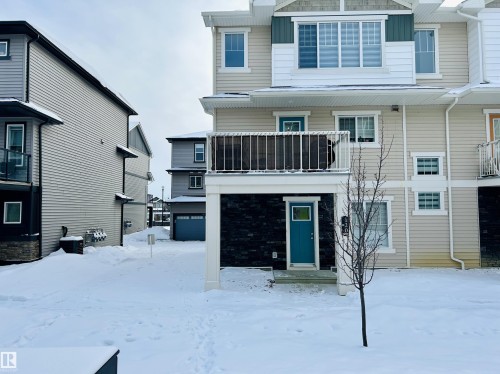 Snow covered rear of property with board and batten siding and a balcony - 120 1530 Tamarack Boulevard, Edmonton, AB - Outdoor With Facade