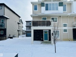 Snow covered rear of property with board and batten siding and a balcony - 
