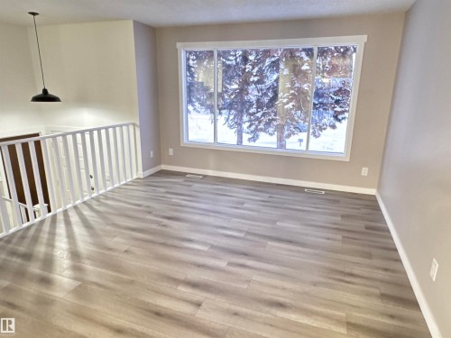 Unfurnished room featuring baseboards and wood finished floors - 4919 49 Avenue, Vimy, AB - Indoor Photo Showing Other Room