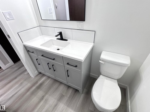 Half bath with vanity and light wood-style flooring - 4919 49 Avenue, Vimy, AB - Indoor Photo Showing Bathroom
