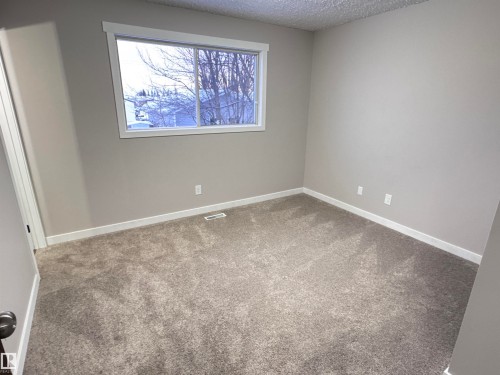 Empty room featuring a textured ceiling and carpet floors - 4919 49 Avenue, Vimy, AB - Indoor Photo Showing Other Room